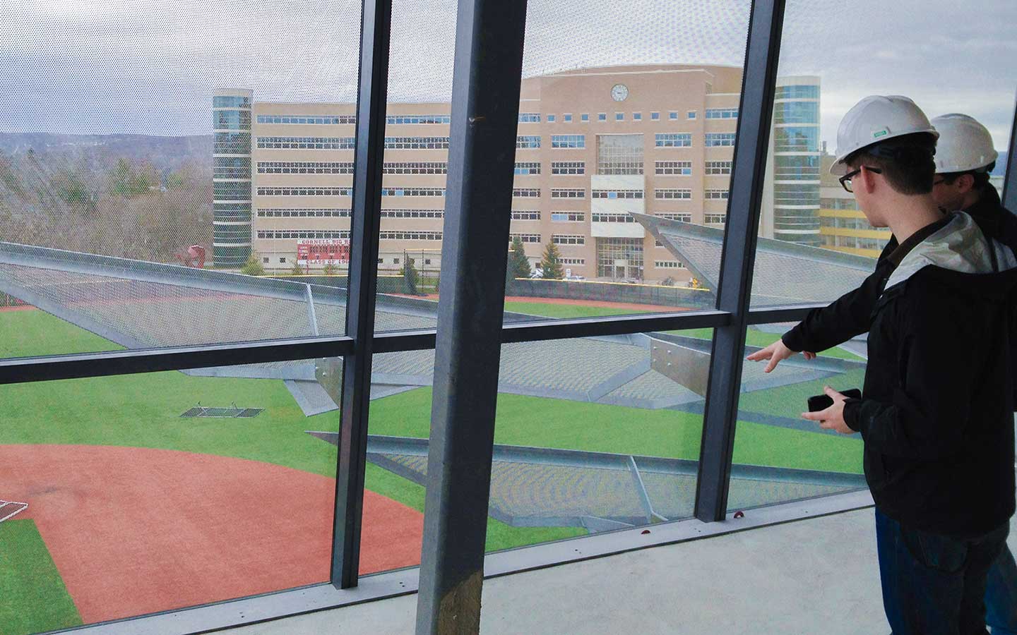 The design team members overlook the window unit integration of the completed facade.