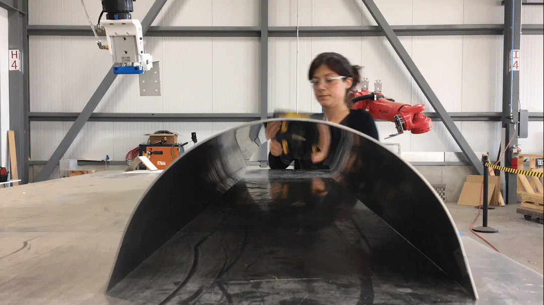 Intern Burcin Nalinci conducting positioning tests on a formed stainless steel part.