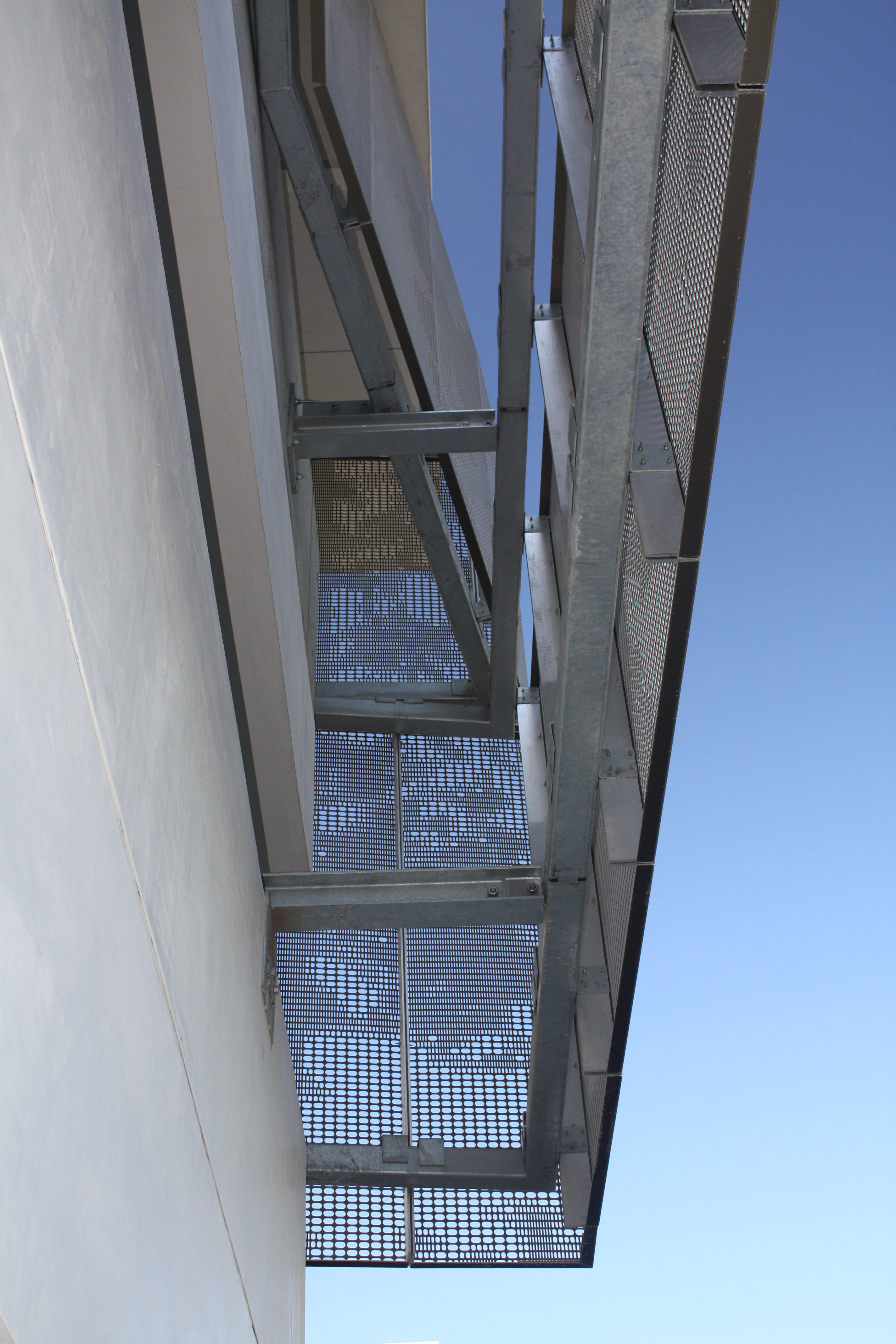 Detail of the perforated zigzag aluminum system used to cool and ventilate the school's parking garage.