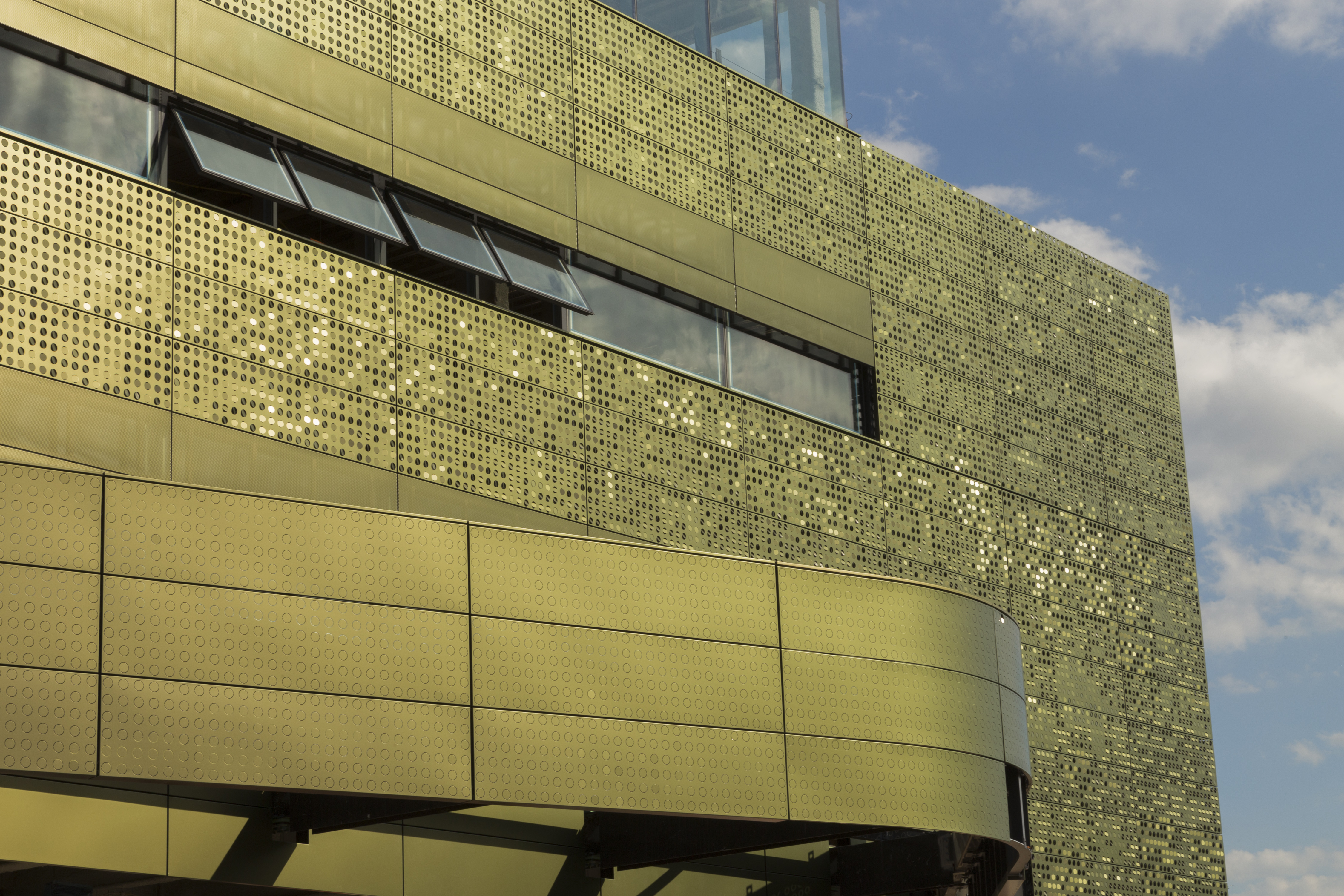 Perforation patterns on color-shift iridescent painted aluminum panels.