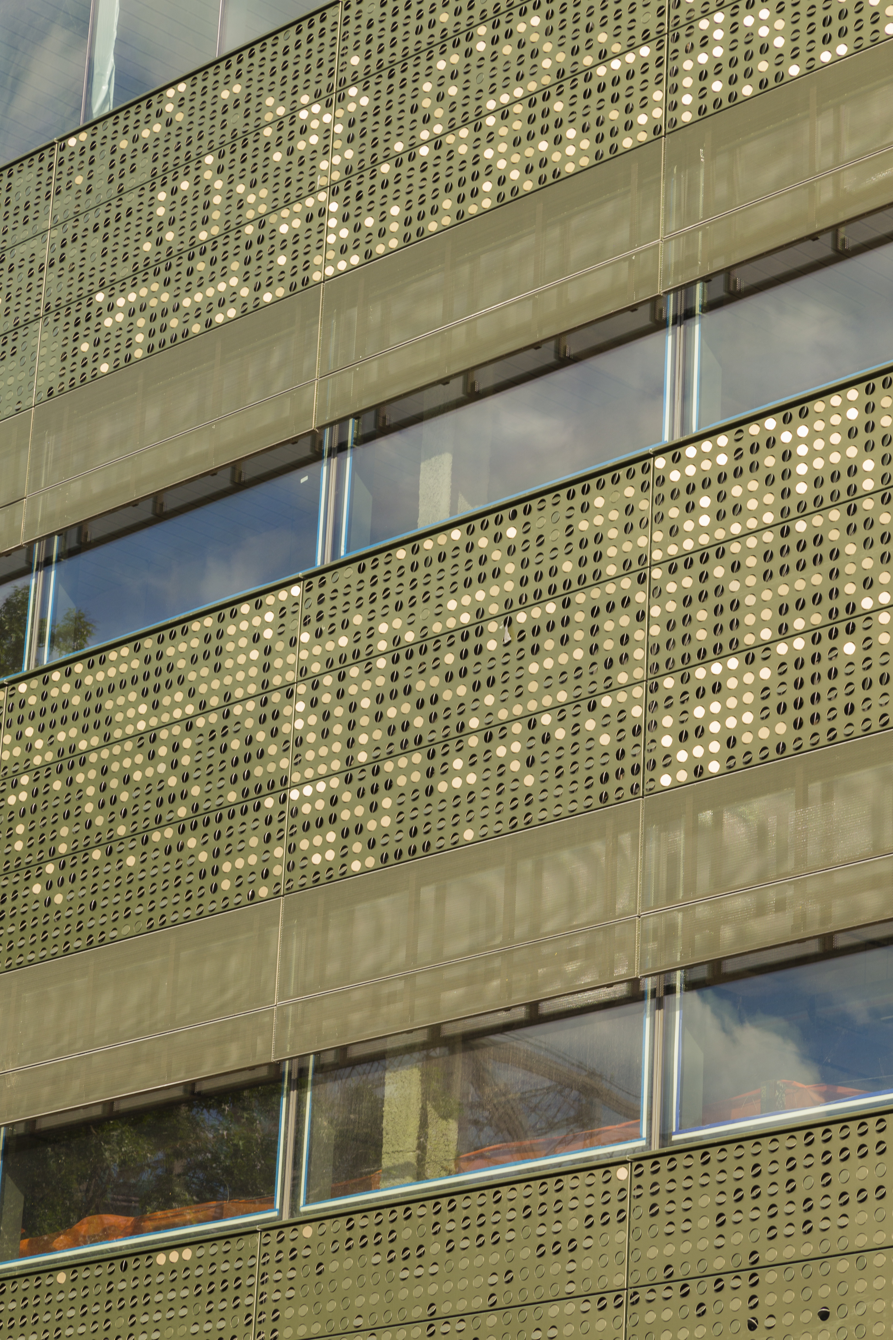 Detail of the perforated metal facade during construction.