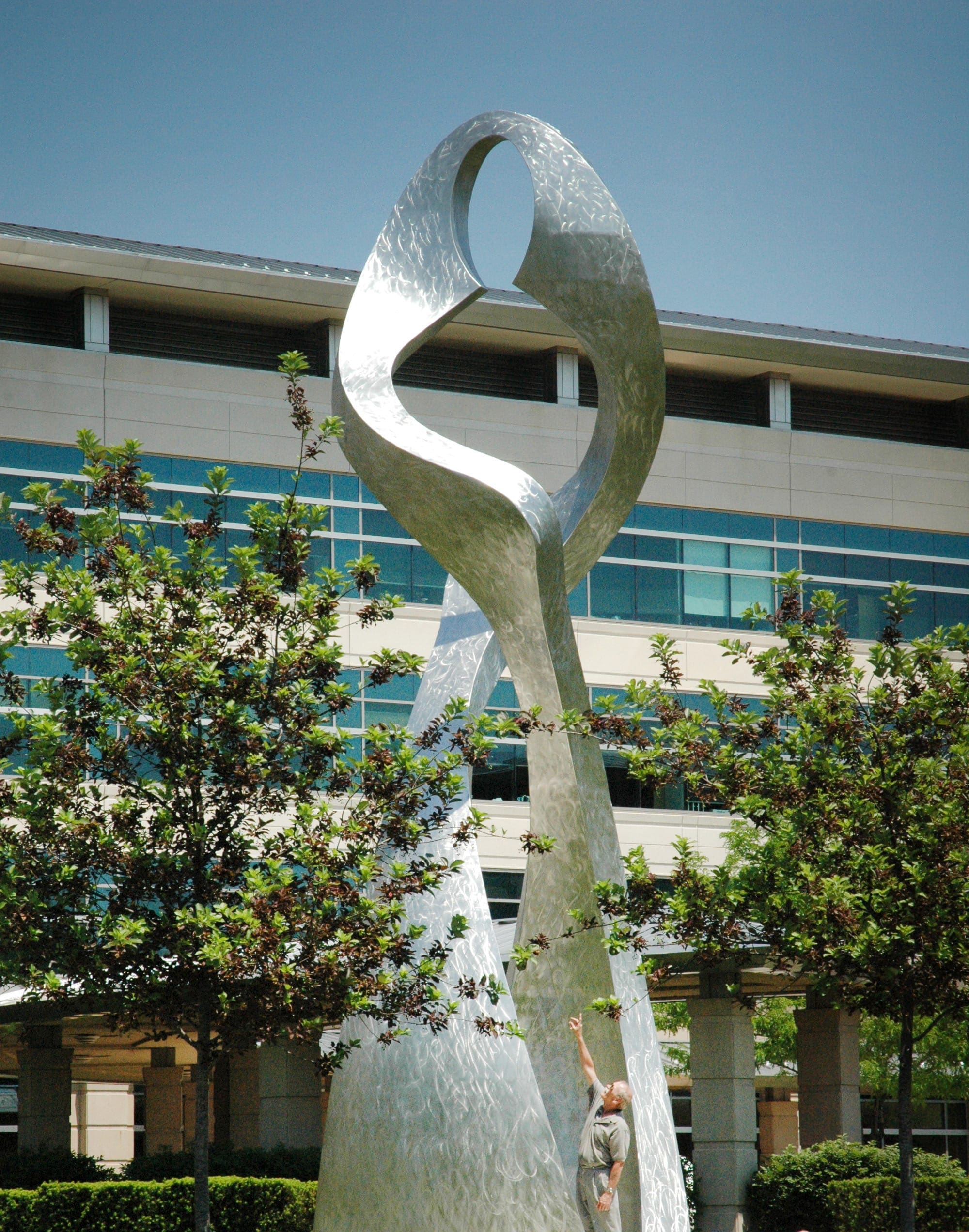 A human figure stands for scale at the base of the sculpture.