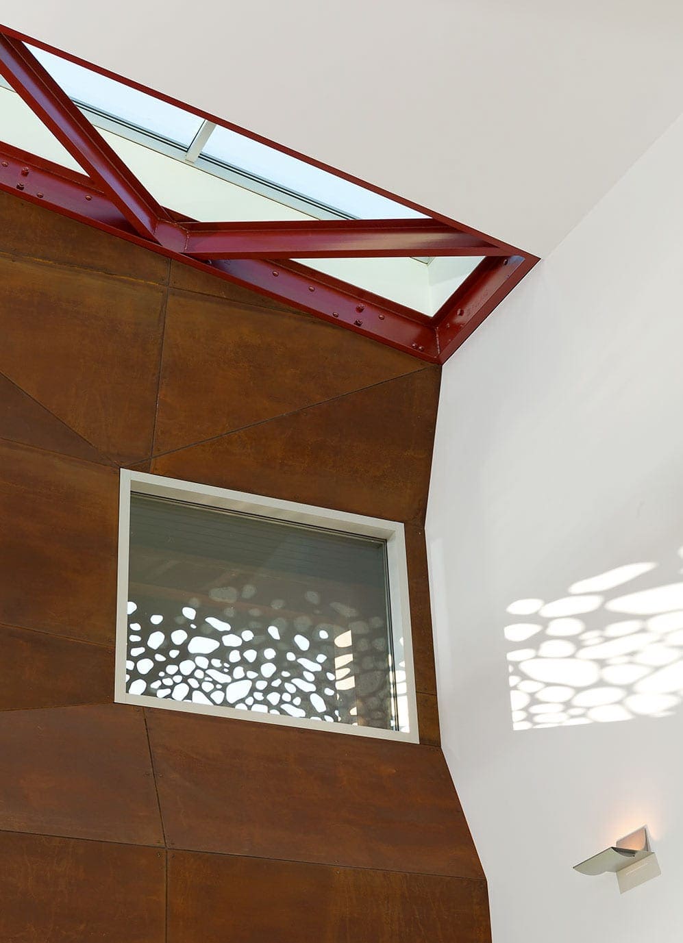 The Solanum Steel exterior of the Gulf Islands Residence appears bright umber in the afternoon light.