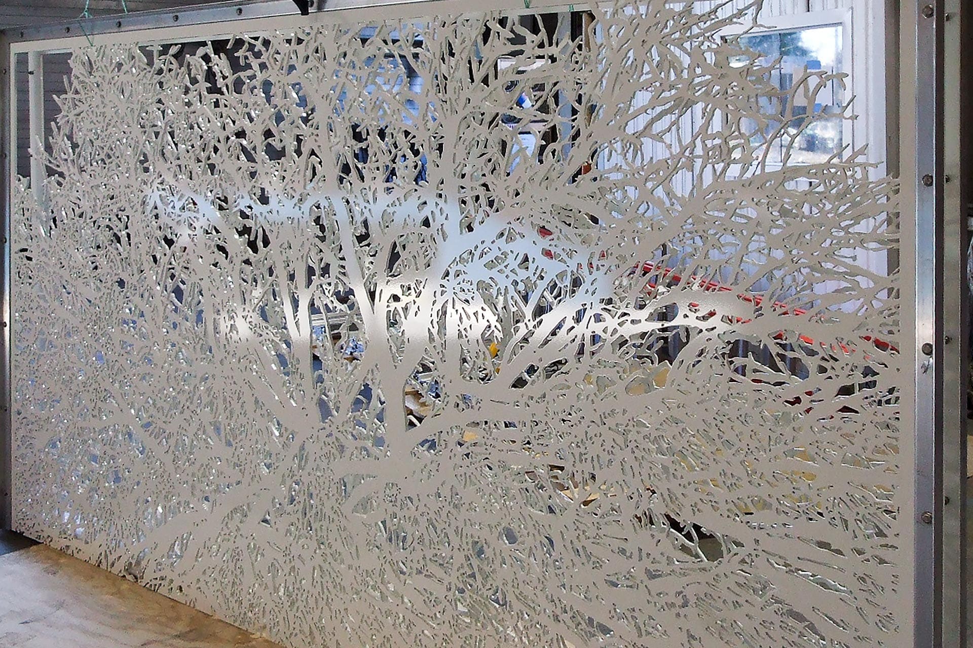 Two layers of water-jet cut and painted aluminum plates.