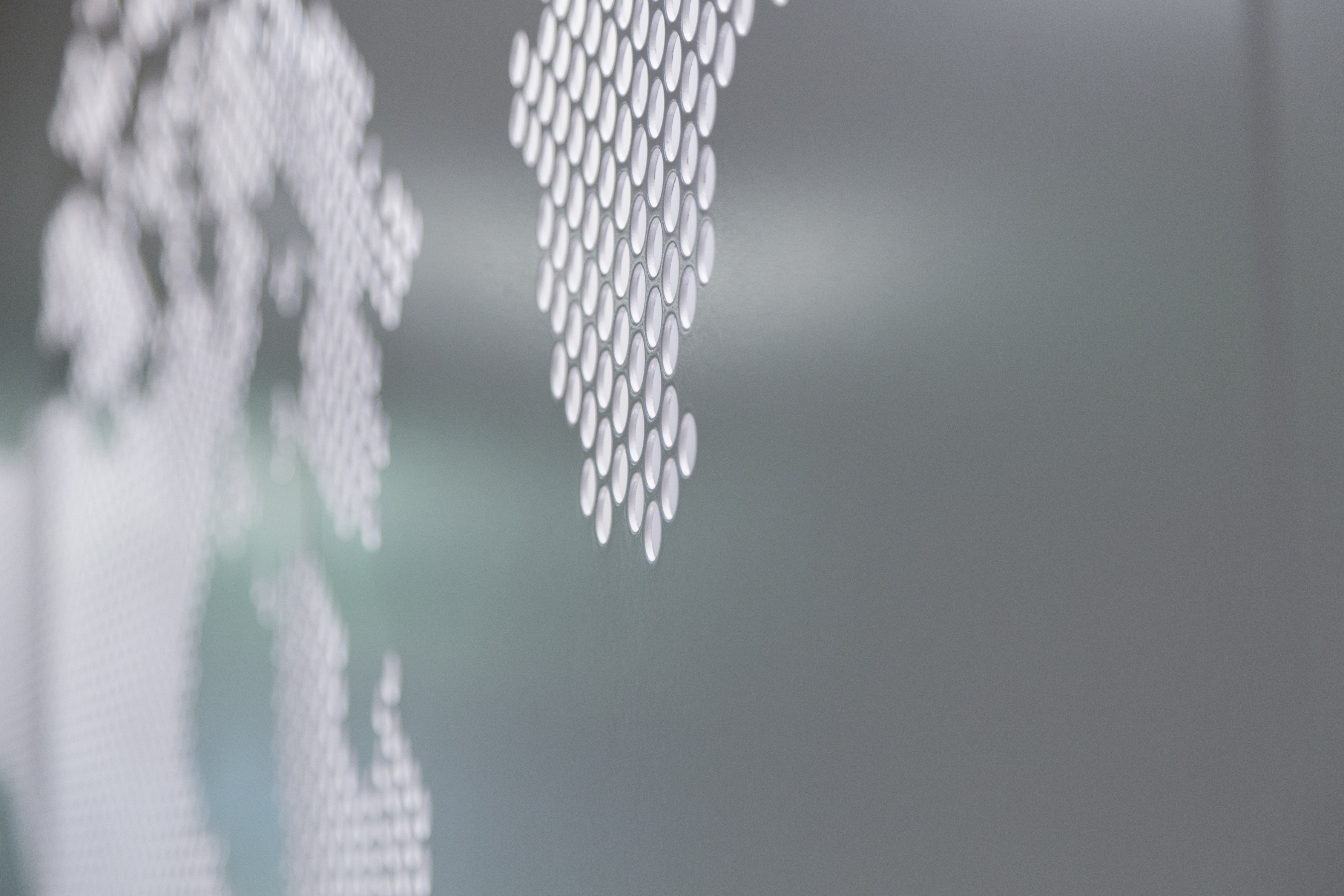 Detail of the perforated metal, painted grey on its exterior and white on its interior.