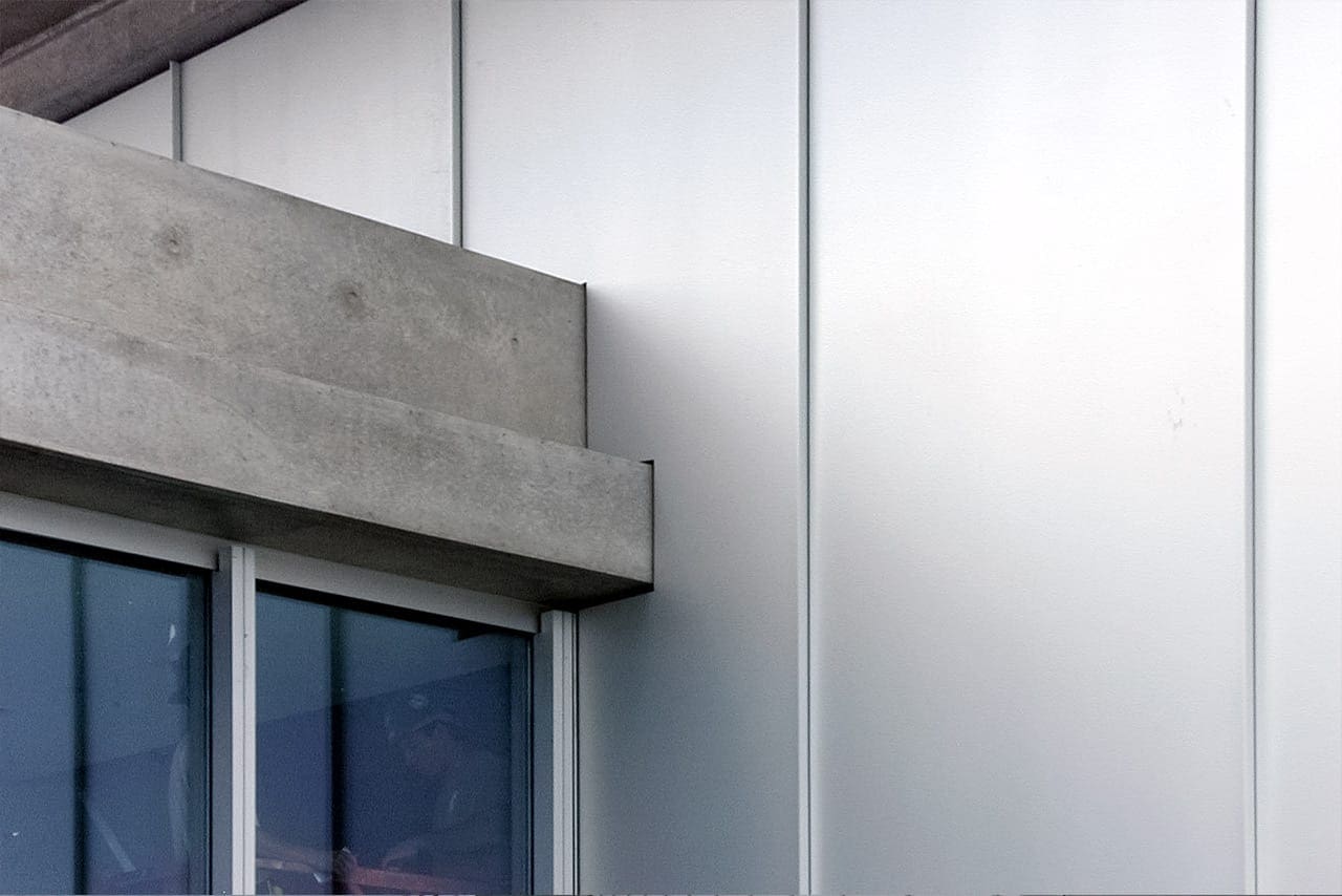 Custom metal details where aluminum wall panels meet concrete slab