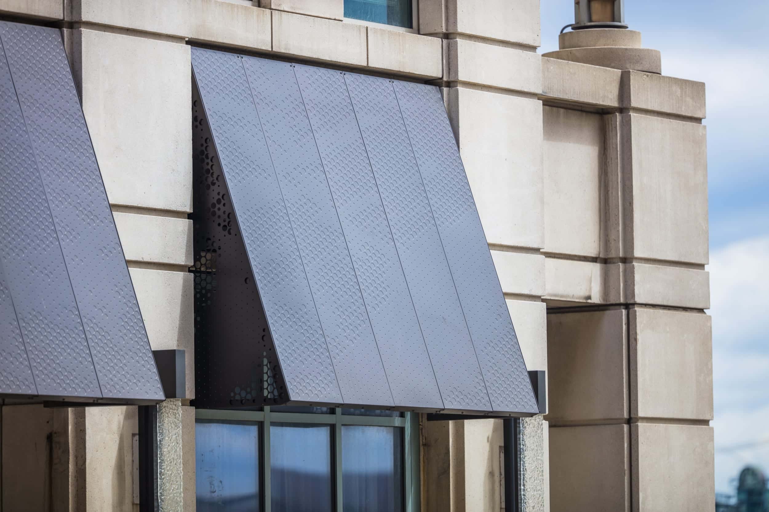 Anodized aluminum panels and structure for a series of awnings. Raised circles on the front create a pattern while still protecting from the elements.