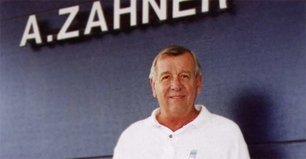 Leo Zahner Jr., in front of the A. Zahner Company sign at its front entrance.