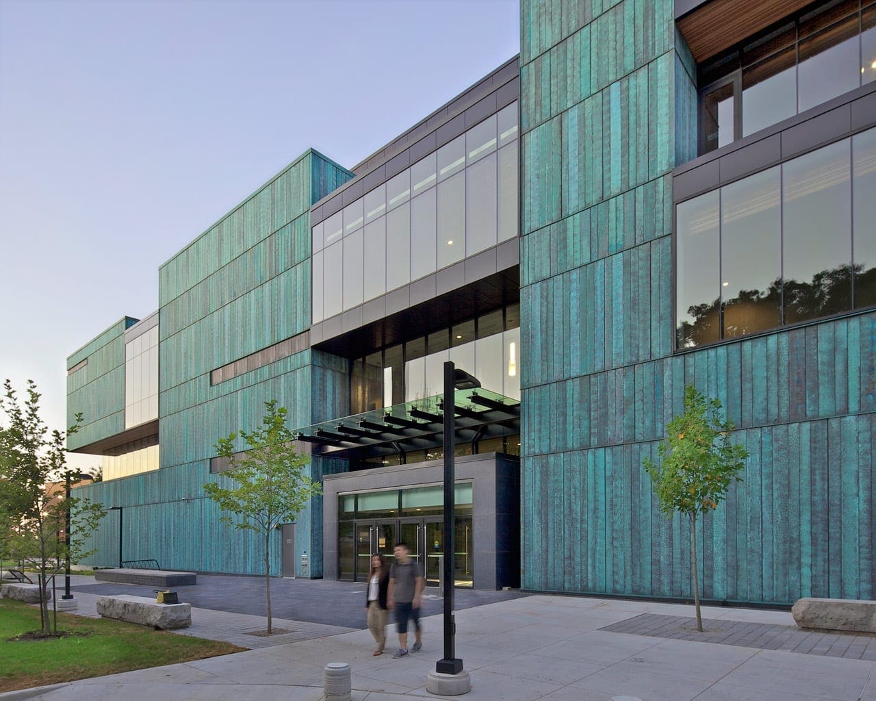 STUDENTS WALKING AMIDST THE BLUE COPPER FACADE of the Instructional Centre.